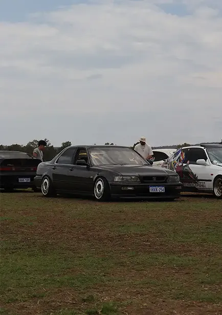 Front 3/4 shot of a grey 90's Honda Prelude at a car meet