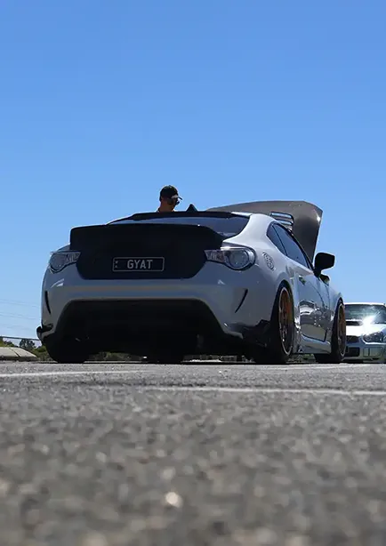 Low rear 3/4 shot of a white and carbon fibre Toyota GT86